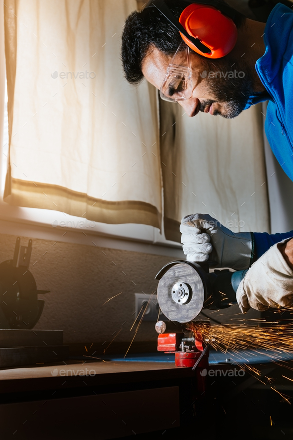 bearded man cutting an iron bar with a circular saw with sparks jumping
